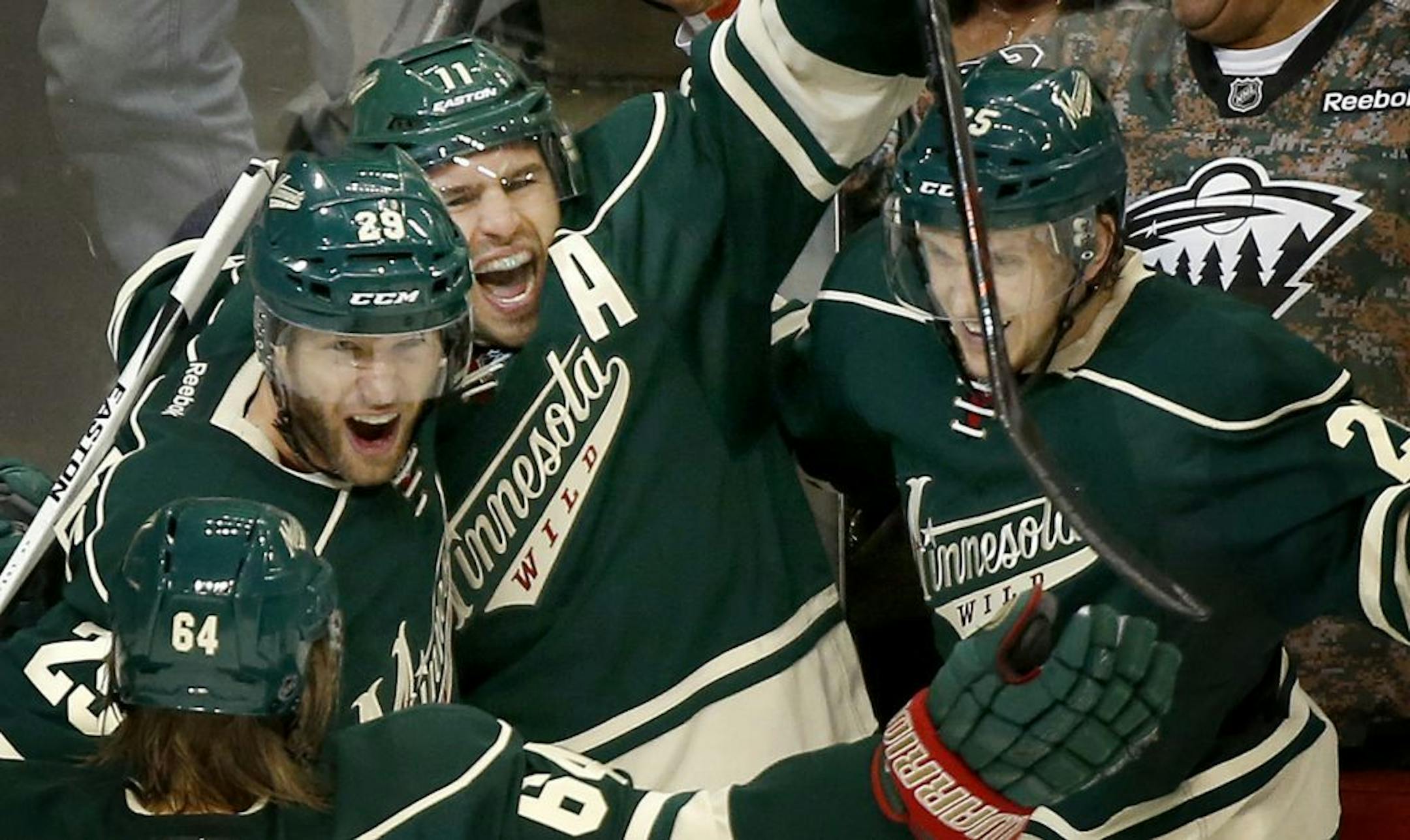 Zach Parise (11) celebrated with teammates after scoring a goal in the second period.