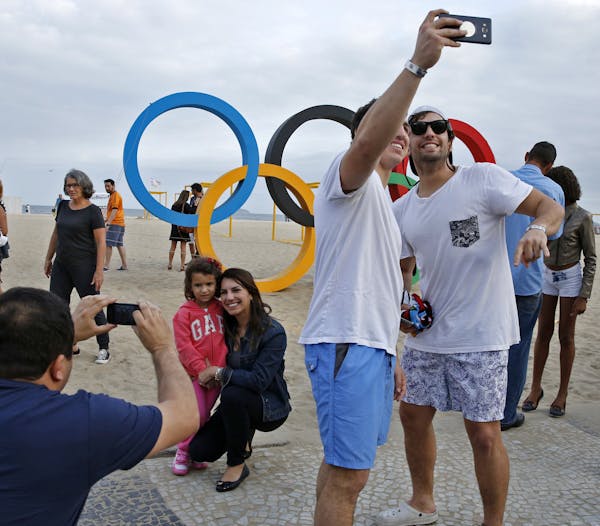 As the opening of the games approached, Olympic fans gathered at the Olympic rings on Copacabana Beach, site of the Beach Volleyball competition. ] 20