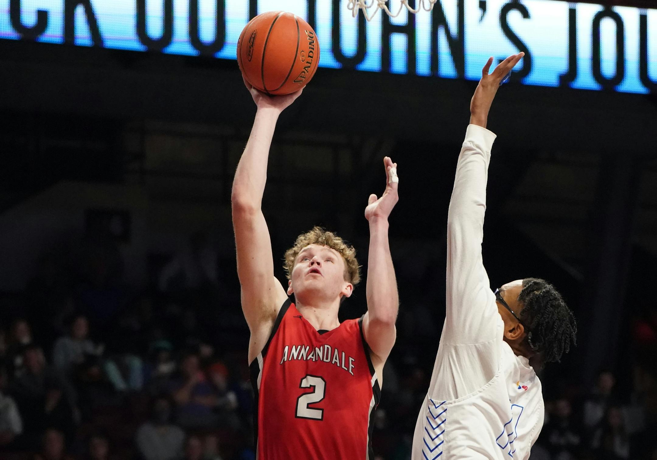 Annandale forward Robert Olson (2) gets a shot off over Minneapolis North's Jacob Butler (11) during the Class 2A championship at Williams Arena. Olson had 15 points in the Cardinals' 60-49 victory. ORG XMIT: MIN2203261513460035