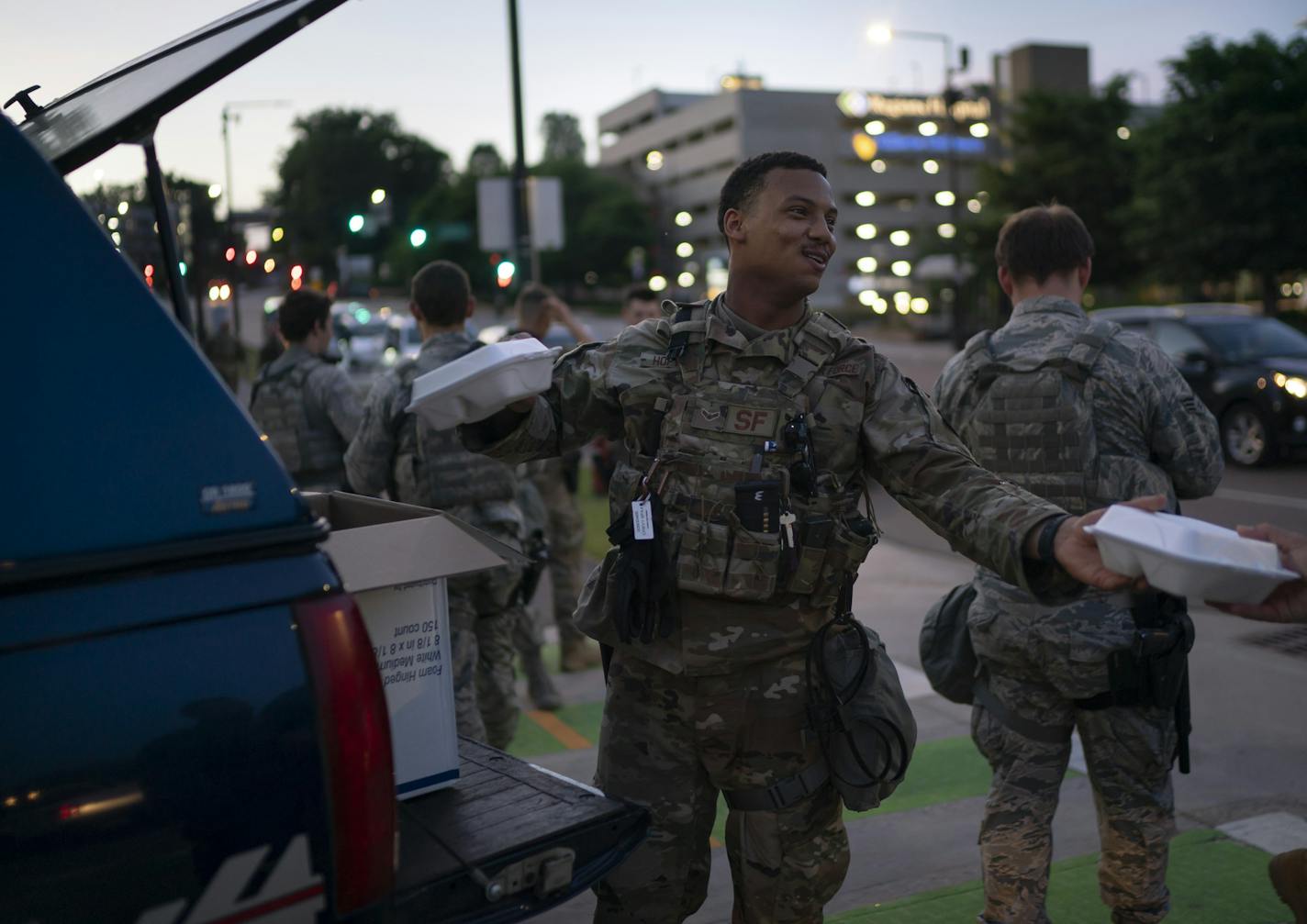 Airman 1st Class Jordan Hopwood handed out meals at dusk to fellow guardsmen as he waited to possibly be deployed to help the St. Paul Police department in St. Paul, Minn., on Monday, June 1, 2020. ] RENEE JONES SCHNEIDER renee.jones@startribune.com