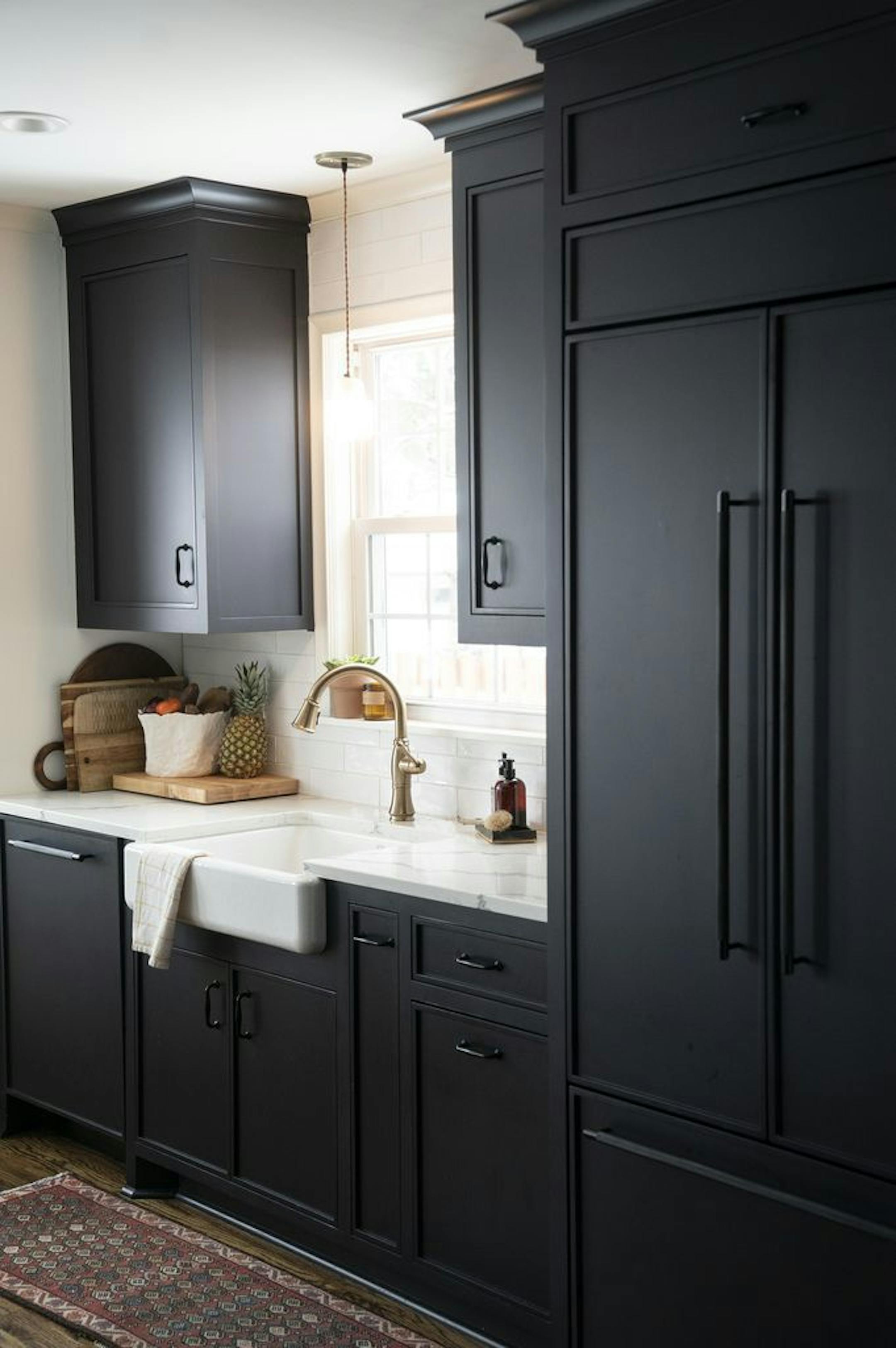 The kitchen contrasts dark cabinets with light countertops.