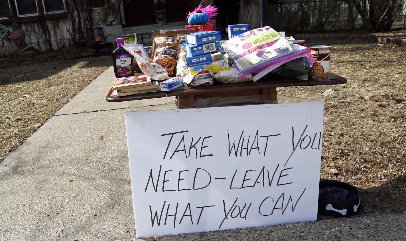 Food for the taking and an invitation to leave food is in front of a south Minneapolis home Monday, March 23, 2020 as Minnesotans care for others during the effort to slow down the coronavirus in the state. (AP Photo/Jim Mone)