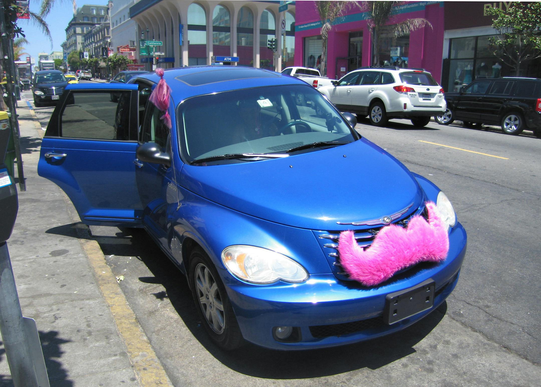 The pink mustache on the grille is the sign of a Lyft vehicle in service.
