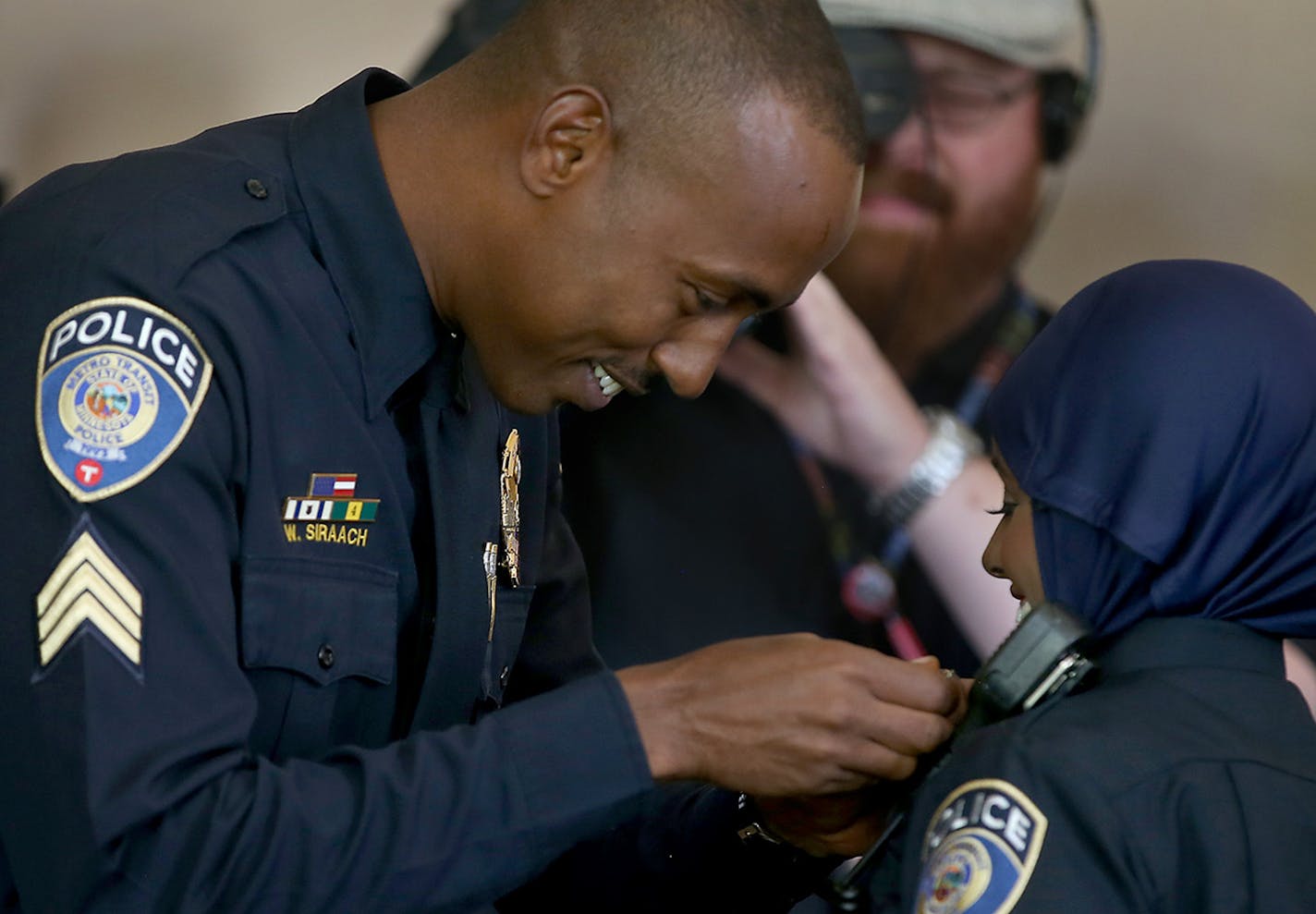 Metro Transit Police Sergeant Waheid Siraach, cq, pinned Kara Mohamed with her badge as she became the first Somali American Metro Police Officer in the Nation during a swearing-in ceremony at the Union Depot, Thursday, April 20, 2015 in St. Paul, MN. ] (ELIZABETH FLORES/STAR TRIBUNE) ELIZABETH FLORES &#x2022; eflores@startribune.com