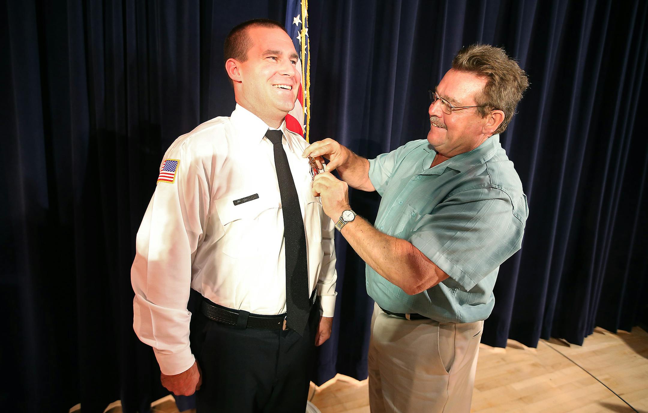 Larry Christopherson, a St. Paul firefighter, placed a firefighter badge on his son Mike Christopherson during the St. Paul Firefighter Graduation at St. Paul College, Friday, September 19, 2014 in St. Paul, MN. ] (ELIZABETH FLORES/STAR TRIBUNE) ELIZABETH FLORES • eflores@startribune.com