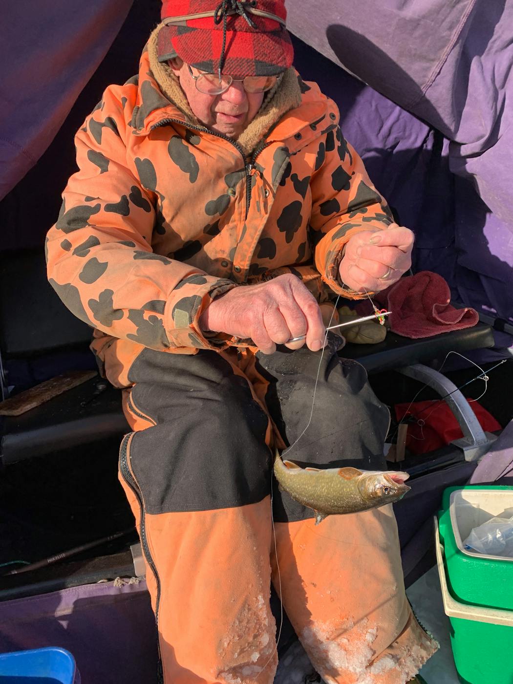 Pete Harris dislodges a lake trout from a rattling spoon that had been baited with a minnow to entice the fish.