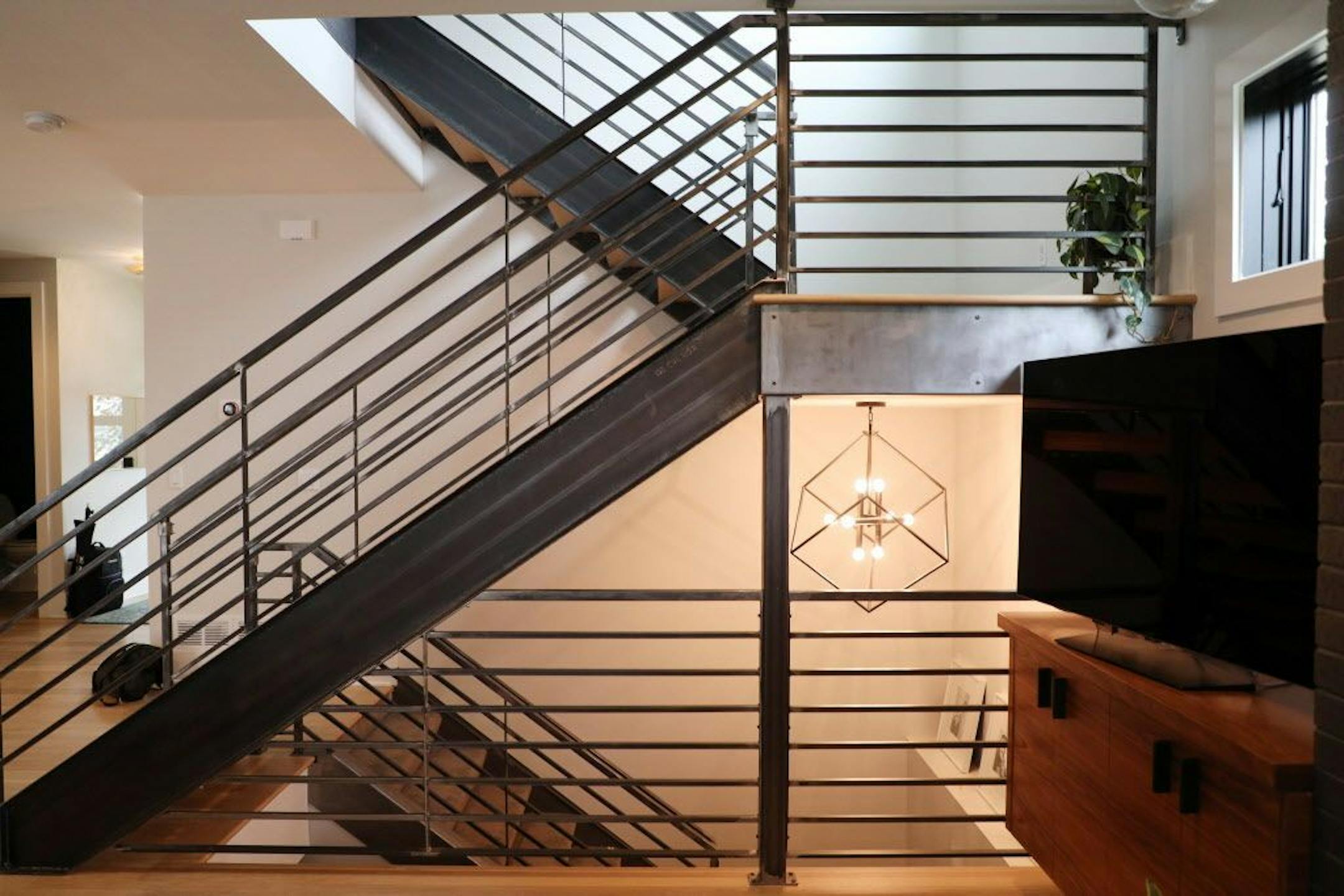 A modern staircase leads to the new second floor.