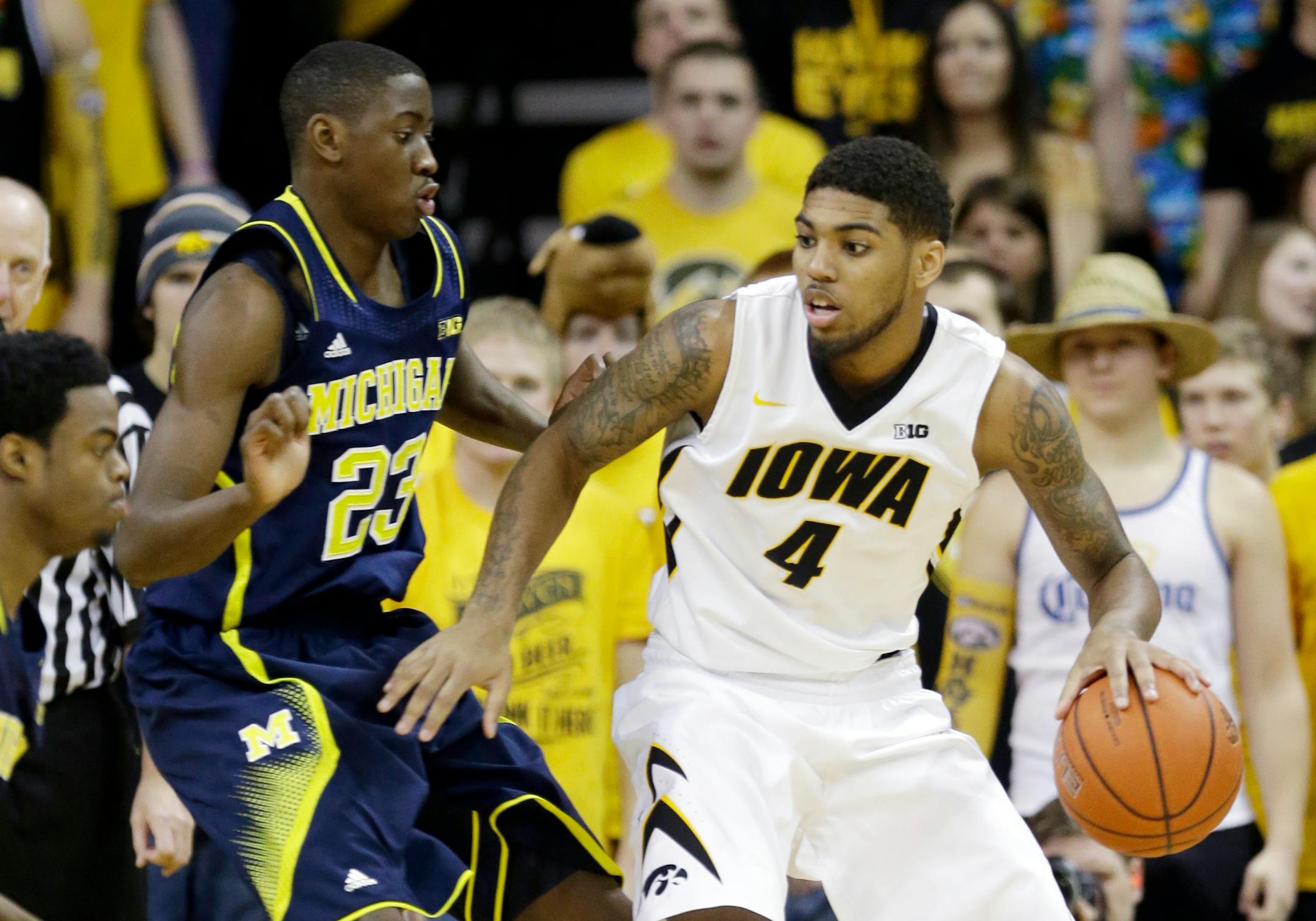 Iowa guard Devyn Marble, right, looks to drive past Michigan guard Caris LeVert (23) during the first half of an NCAA college basketball game, Saturday, Feb. 8, 2014, in Iowa City, Iowa. (AP Photo/Charlie Neibergall)