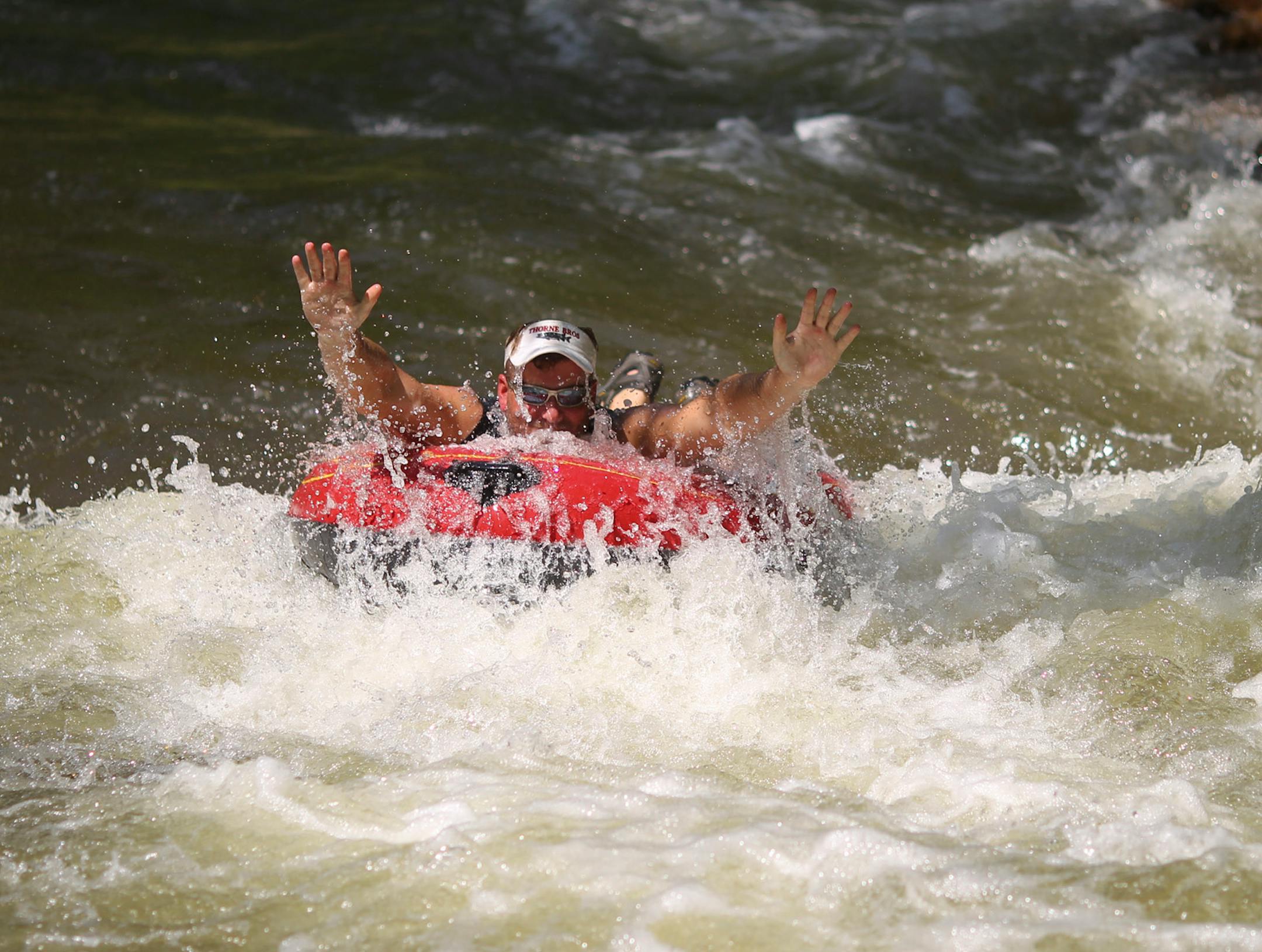 With temperatures edging over 100 degrees in the Twin Cities Tuesday afternoon, Minneahaha Park in Minneapolis was relatively free of crowds, giving those who wanted to cool off in Minnehaha Creek plenty of space. IN THIS PHOTO: Dave LeCompte of Minneapolis floated down Minnehaha Creek in an inflatable raft along with a couple of buddies (not seen in this photo) Tuesday afternoon. They had planned to go all the way to the Mississippi River, but stopped after few hundred yards because of the volu