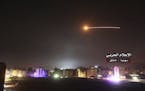 This photo provided early Thursday, May 10, 2018, by the government-controlled Syrian Central Military Media, shows missiles rise into the sky as Isra