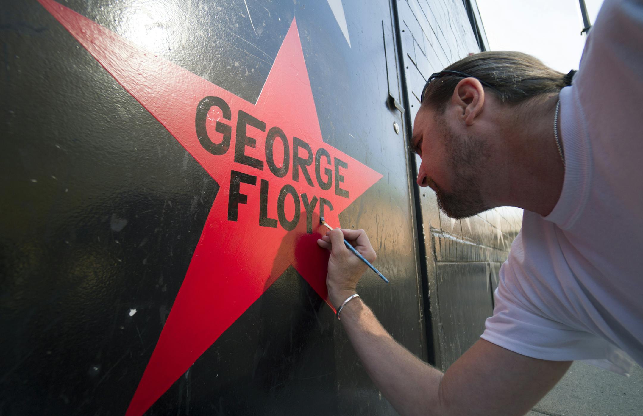 First Avenue nightclub's iconic star facade is getting its once-per-decade paint job this week, but with a couple sign-of-the-times twists: Due to pandemic-related budget constraints, the entire building will not be repainted as usual. One new star is being added with George Floyd's name on it painted in red. The marquee is also getting a makeover back to the skyline-style logo the building had in the "Purple Rain" era. Here, Kory Lidstrom, owner of Indy Painting, adds Greoge Floyd's name to a r