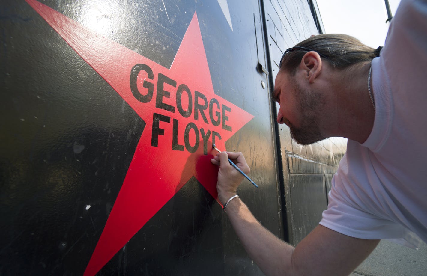 First Avenue nightclub's iconic star facade is getting its once-per-decade paint job this week, but with a couple sign-of-the-times twists: Due to pandemic-related budget constraints, the entire building will not be repainted as usual. One new star is being added with George Floyd's name on it painted in red. The marquee is also getting a makeover back to the skyline-style logo the building had in the "Purple Rain" era. Here, Kory Lidstrom, owner of Indy Painting, adds Greoge Floyd's name to a r