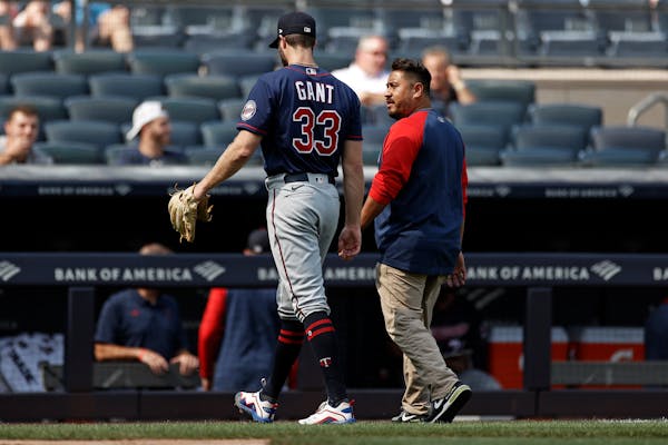 Minnesota Twins pitcher John Gant (33) walks off the field with a team trainer after being taken out of the game against the New York Yankees during t