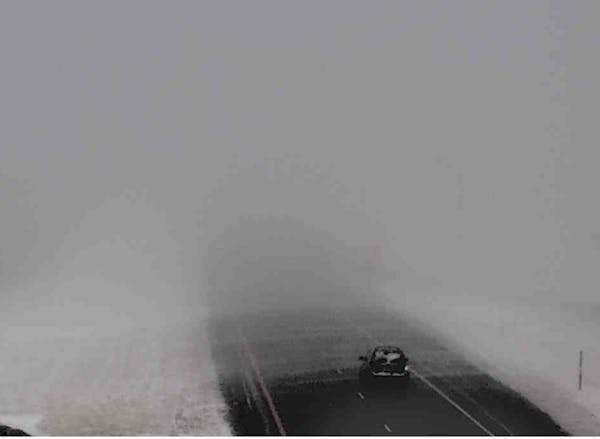 A motorist made their way along I-90 in whiteout conditions west of Fairmont Friday before MnDOT shut down the freeway.