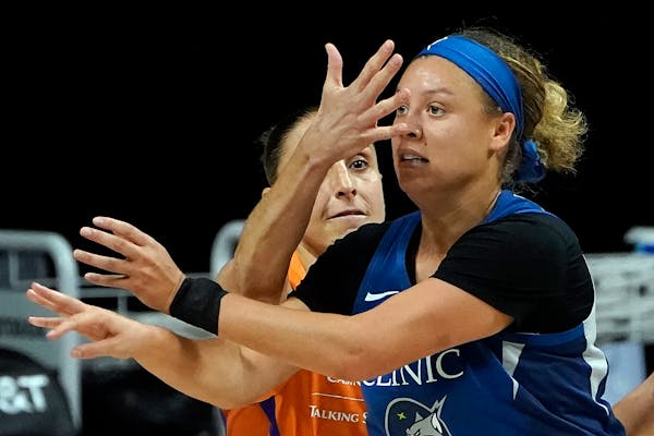 Phoenix Mercury guard Diana Taurasi, background, blocks Minnesota Lynx guard Rachel Banham's vision during the first half of a WNBA playoff basketball