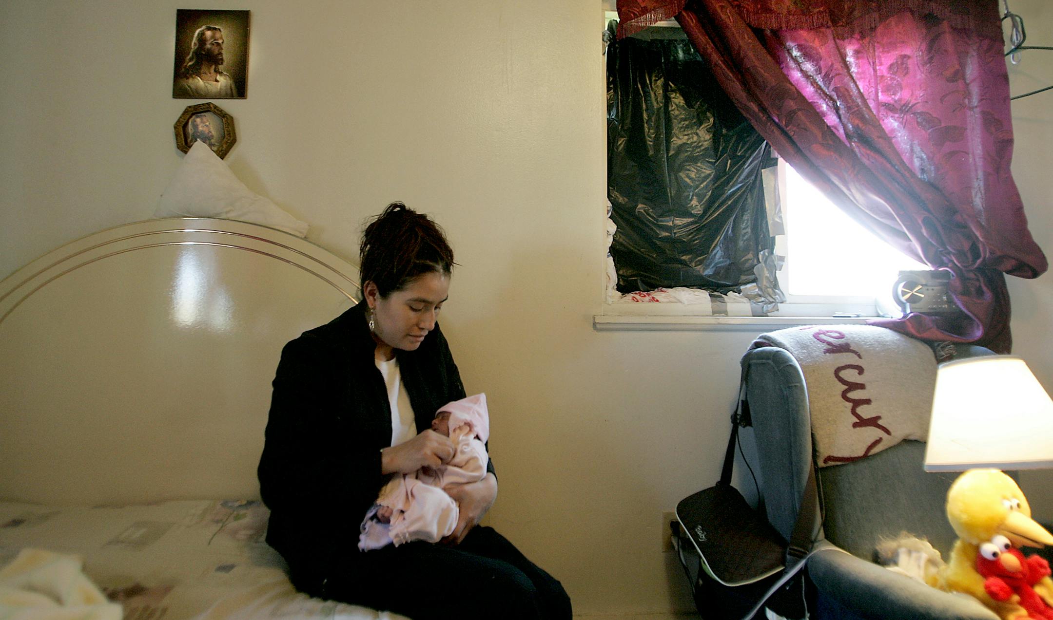 Teresa Alcantor cuddled with her newborn baby, Kelly, on a bug-ridden mattress in their St. Paul apartment. Alcantor and her husband, Joel Ramos, were preparing to leave the apartment over a number of problems, including bug infestation, lack of heat, defective appliances, broken doors and mold. ]