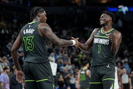 Minnesota Timberwolves forward Nathan Knight (13) and guard Anthony Edwards (1) celebrate during the final seconds of a win over the Houston Rockets i