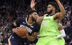 New Orleans Pelicans' Anthony Davis, left, drives as Minnesota Timberwolves' Karl-Anthony Towns defends in the second half of an NBA basketball game S