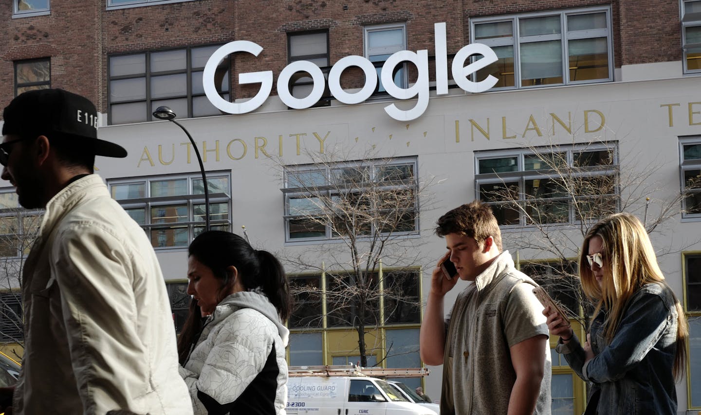 FILE - In this Dec. 4, 2017, file photo, people walk by the the Google office building on Ninth Avenue in New York. Google has been quietly expanding its footprint in the city and is reportedly close to reaching a $2.4 billion deal to add the landmark Chelsea Market building in the Meatpacking District to its already substantial New York campus. It's the latest example of a big-name tech firm expanding in New York City, which has, for years, been trying to stake a claim as Silicon Valley East. (