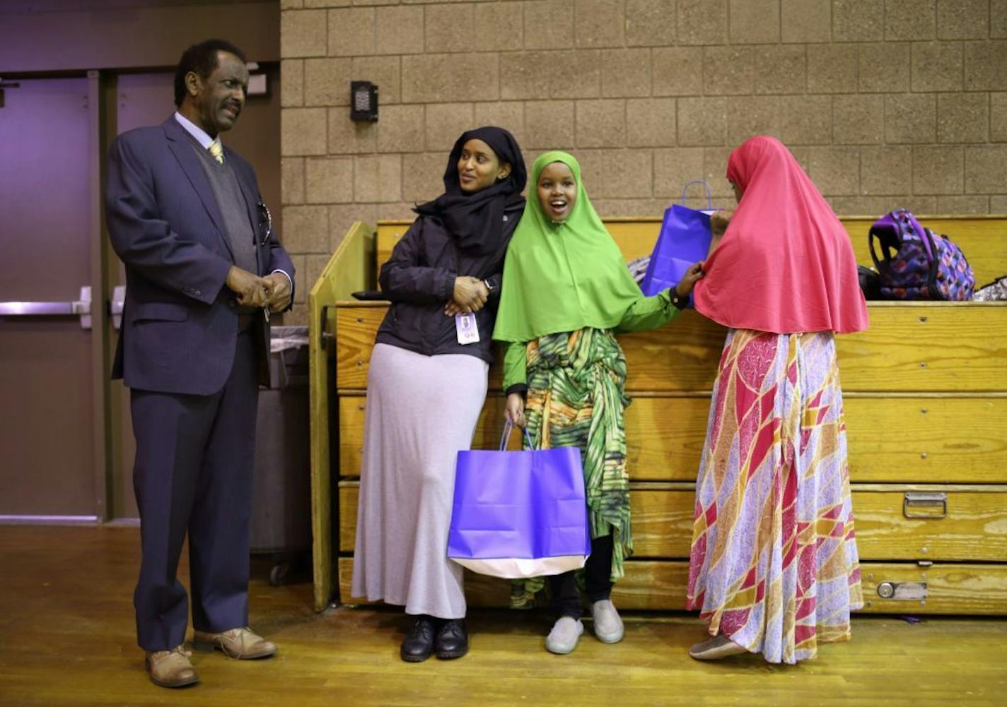 Mohamed Mohamud visited with program staffer Saytun Bundid as they stood near two participants, both of whom have a bag of goodies that all received on the final day of the program Tuesday.