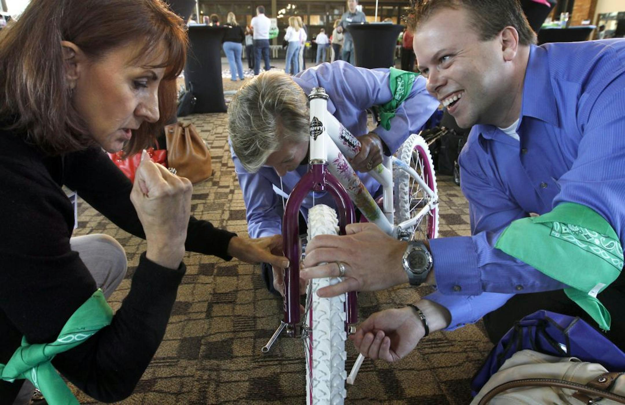 Jacqui Barton, left, Susan Jeska and Kristofer O'Brien rushed to put their team bike together at the Milwaukee Road Depot skating rink pavilion in Minneapolis.