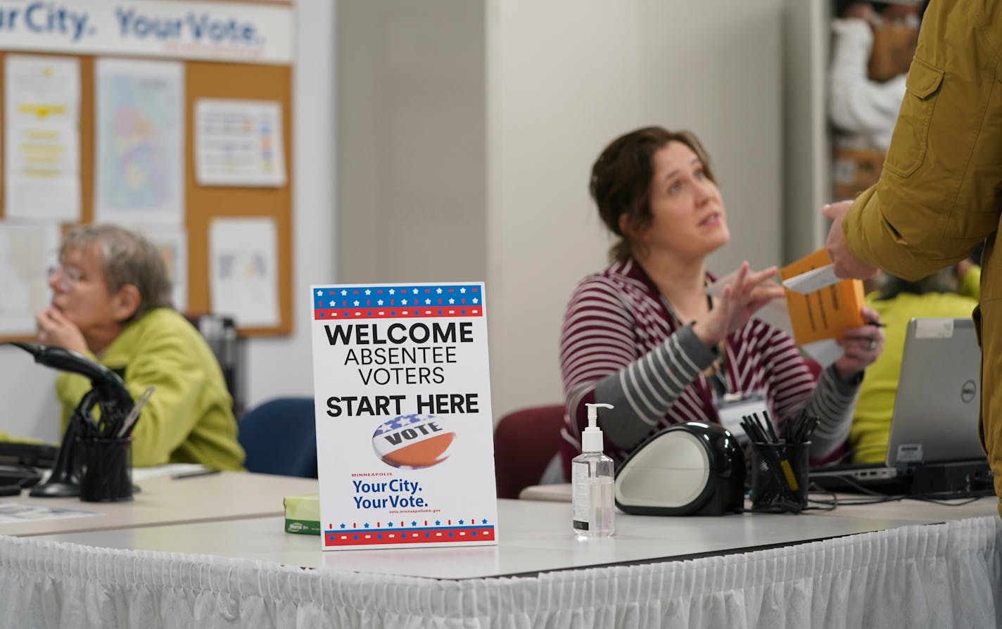 In this Jan. 17, 2020, photo, a poll worker spoke with a voter as Minneapolis Early Voting Center opened, in Minneapolis.