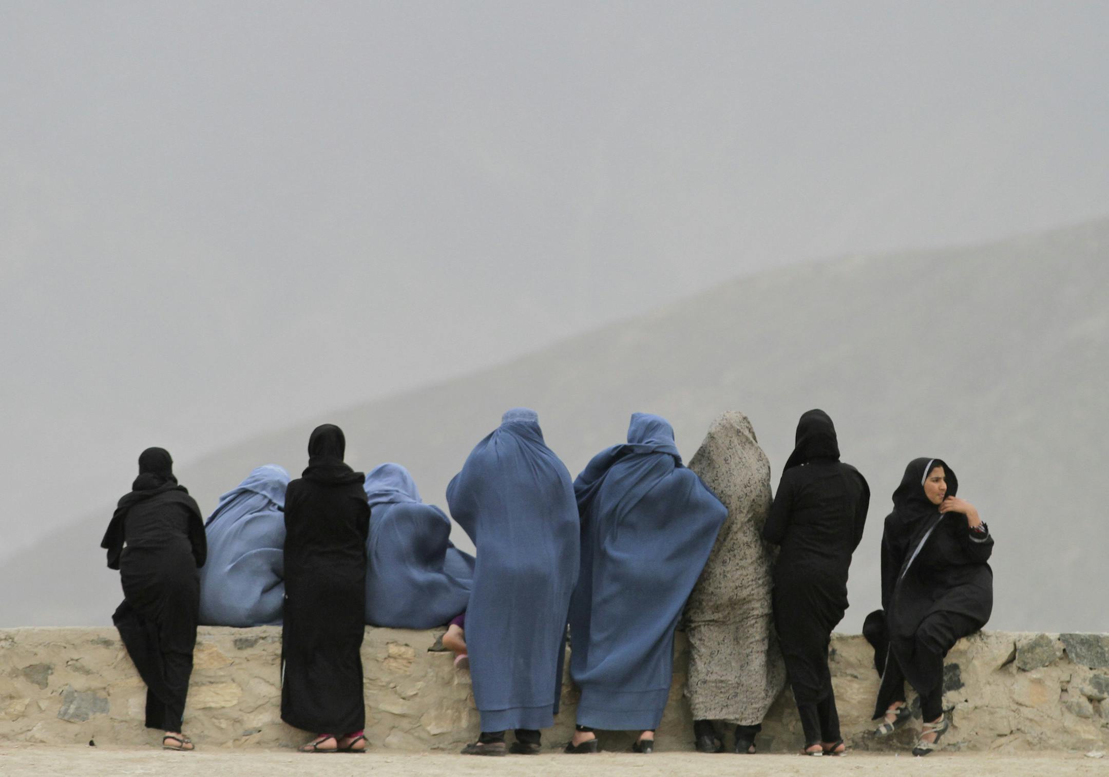 Afghani women look out over Kabul from the Naderkhan hill in Kabul, Afghanistan, Tuesday, April, 30, 2013. The Taliban were thrown out 12 years ago ending five years of rule and regressive laws that enforced a tribal tradition and culture more than religious compulsions, denying girls schools and ordering women to stay indoors unless accompanied by a male. (AP Photo/Ahmad Jamshid)