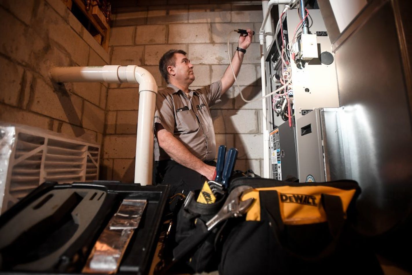 Michael Engel, with Marsh Heating and Air Conditioning, used a gas analyzer to test for elevated carbon monoxide levels in a heater's exhaust during a tune-up Thursday.