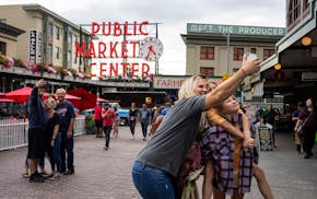 Visitors pose for selfies at Pike Place Market in Seattle on Aug. 26, 2022.