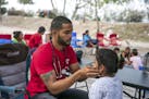 Dr. Dairon Elisondo Rojas, a doctor from Cuba, treats patients in a migrant camp in Matamoros, Mexico, Dec. 6, 2019. Rojas, waiting for asylum in the 