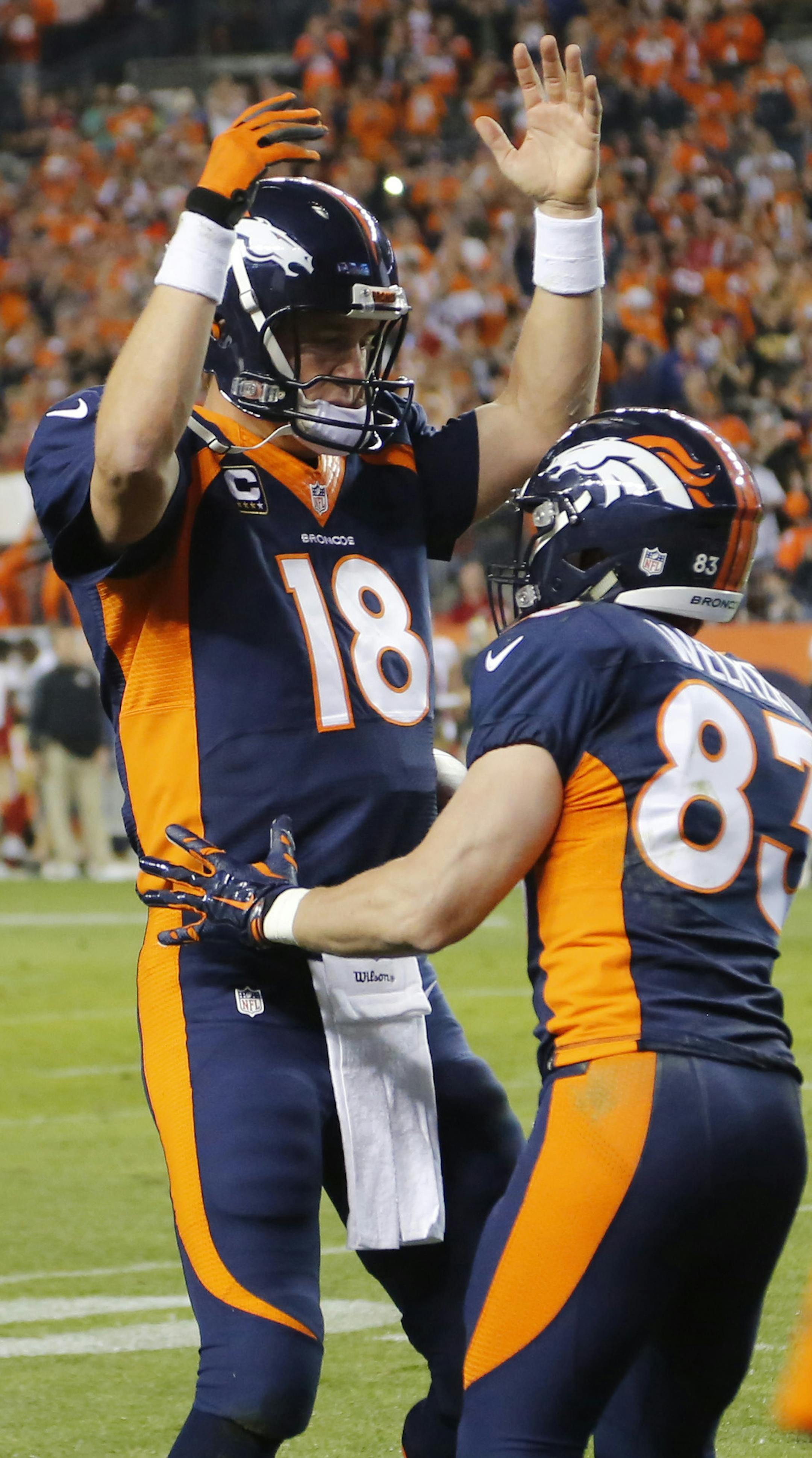 Denver Broncos quarterback Peyton Manning (18) celebrates his 509th career touchdown pass with teammate Wes Welker during the first half of an NFL football game, Sunday, Oct. 19, 2014, in Denver. (AP Photo/Jack Dempsey)