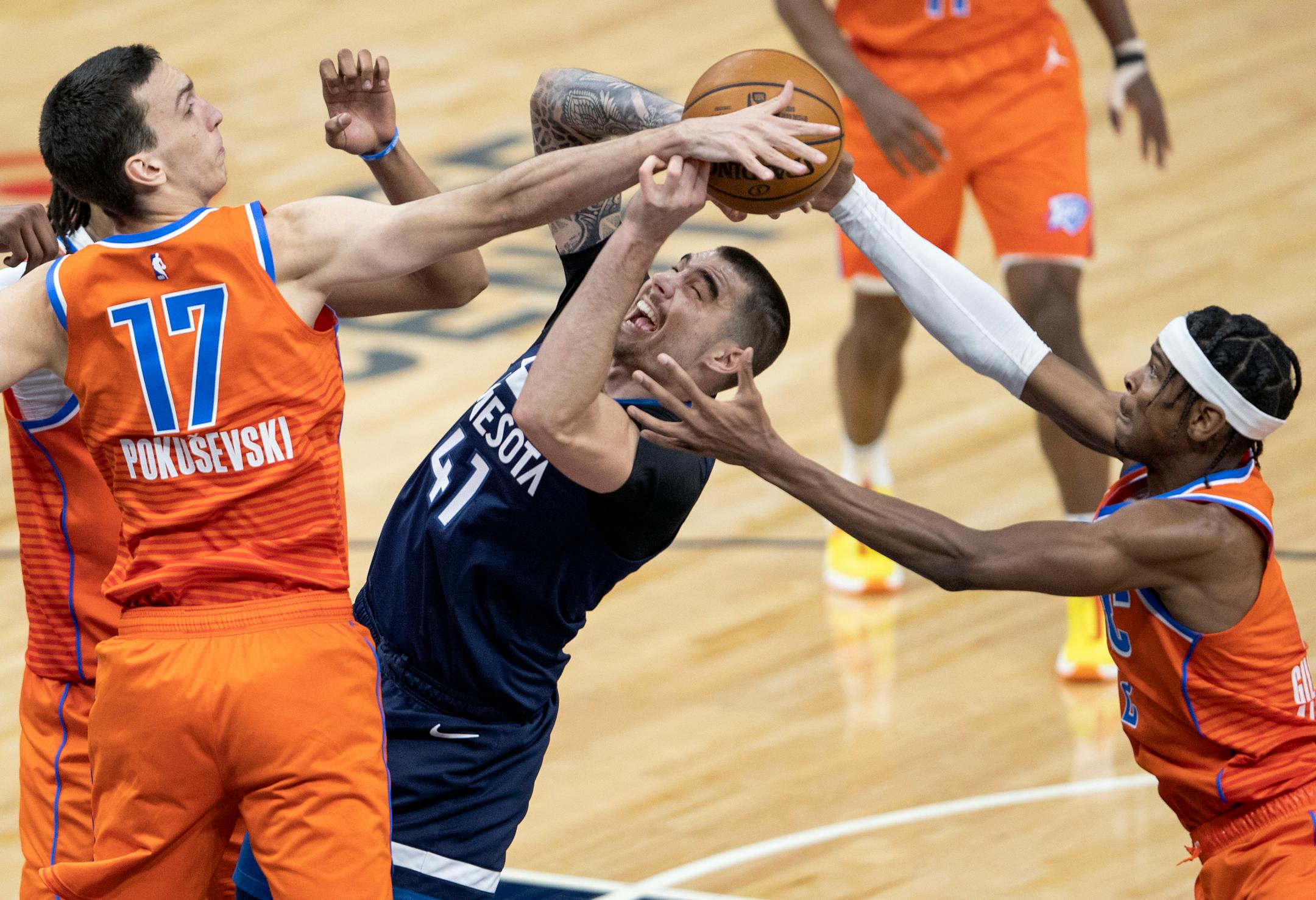 Juancho Hernangomez (41) of the Minnesota Timberwolves was blocked by Aleksej Pokusevski (17) and Shai Gilgeous Alexander (2) of the Oklahoma City Thunder in the fourth quarter.