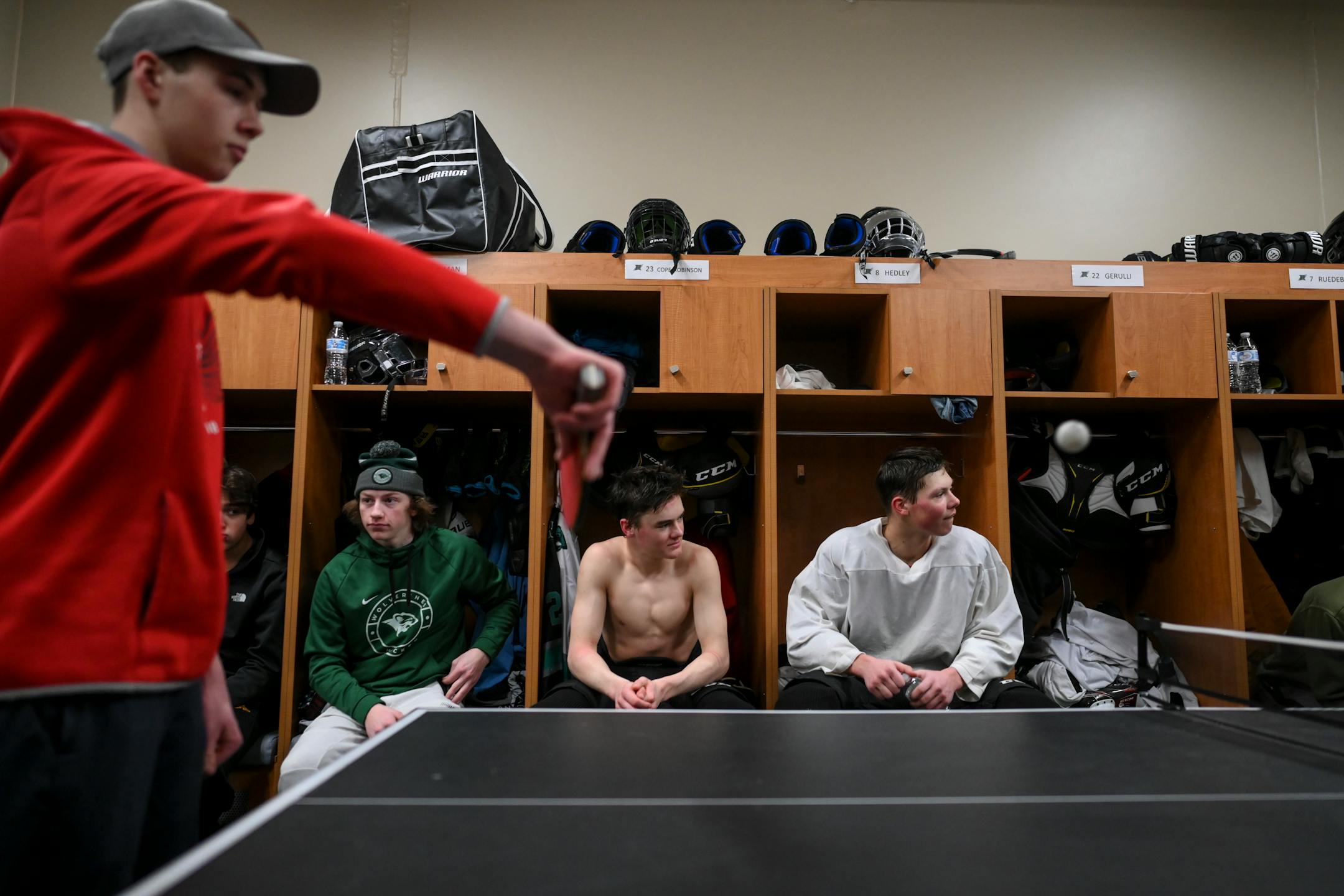Rock Ridge's Evan Skelton, left, plays ping pong after practice as his teammates sit in their lockers Tuesday, Feb. 22, 2022 at the Iron Trail Motors Event Center in Virginia, Minn.