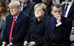 U.S President Donald Trump, left, German Chancellor Angela Merkel and French President Emmanuel Macron attend ceremonies at the Arc de Triomphe Sunday