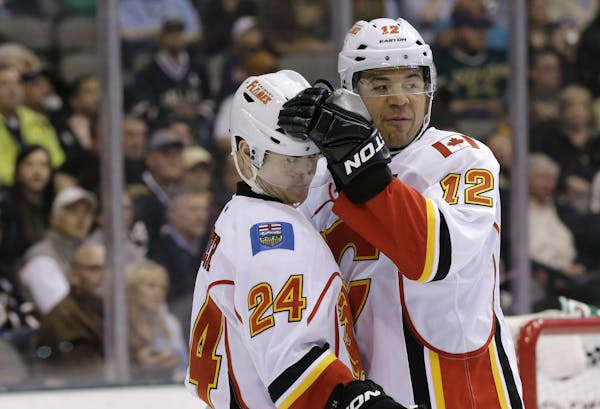 Jiri Hudler receives a tap on the helmet from Jarome Iginla, who was traded late Wednesday night from the Flames to Pittsburgh.