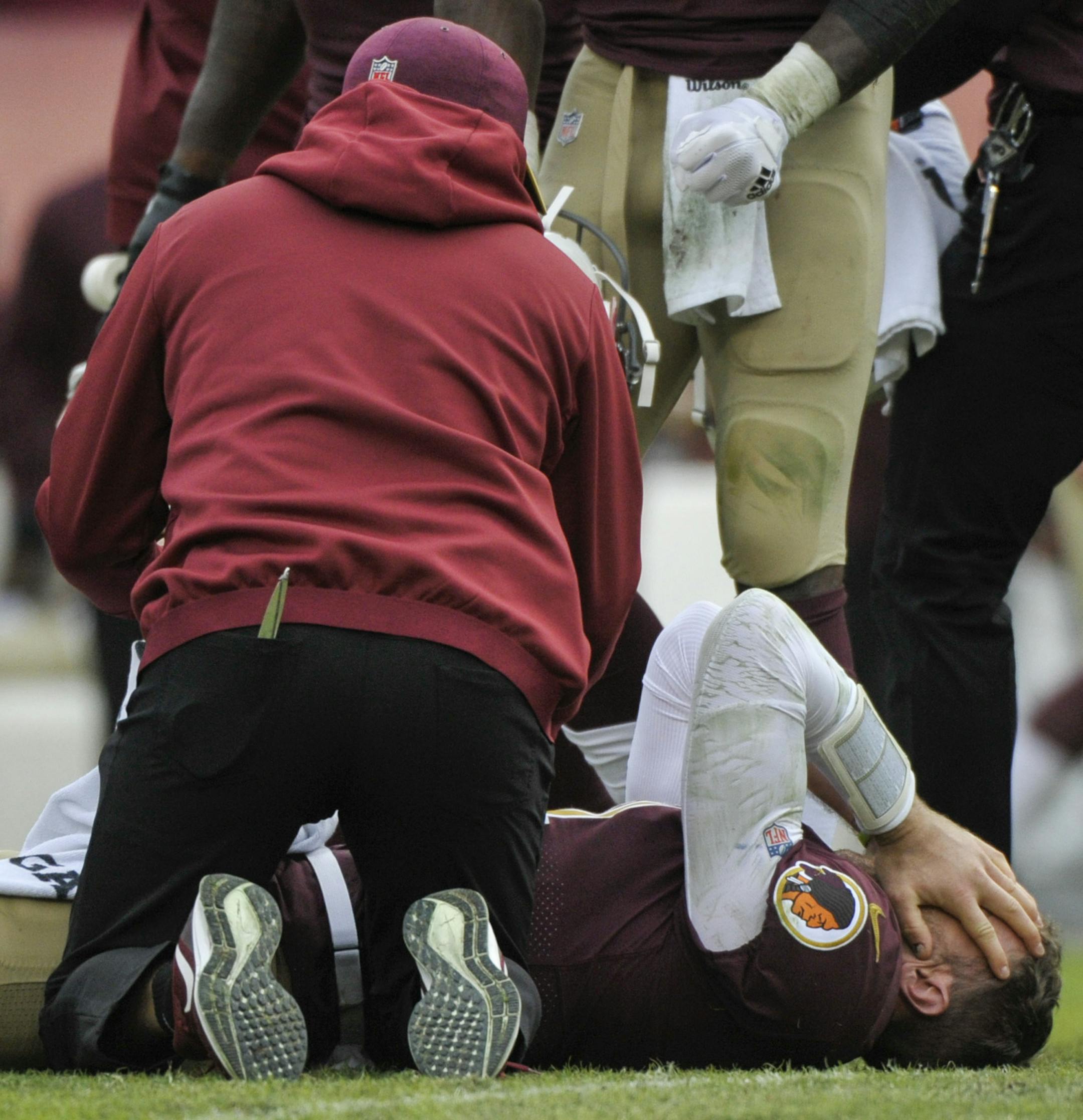 Washington Redskins quarterback Alex Smith, bottom, reacts after an injury during the second half of an NFL football game against the Houston Texans, Sunday, Nov. 18, 2018, in Landover, Md. (AP Photo/Mark Tenally)