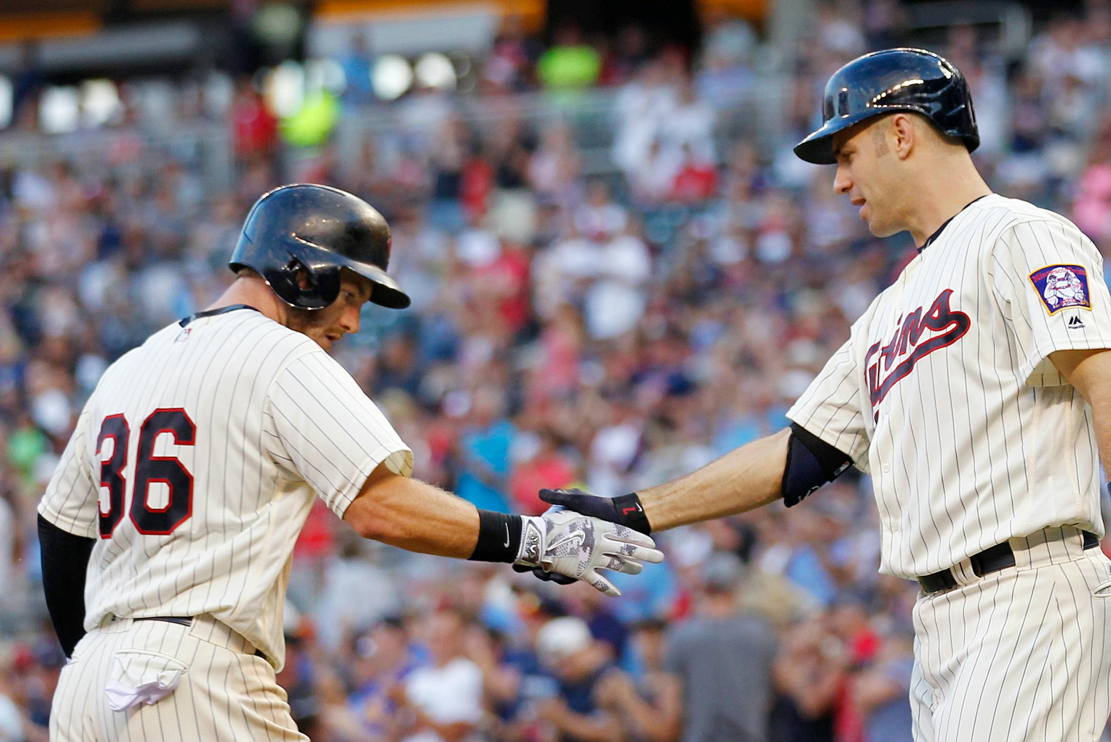 Minnesota Twins Robbie Grossman (36) is congratulated by teammate' Joe Mauer after hitting a home run against the Kansas City Royals in the fifth inning during a baseball game on Saturday, Aug., 13, 2016, in Minneapolis.(AP Photo/Andy Clayton-King)