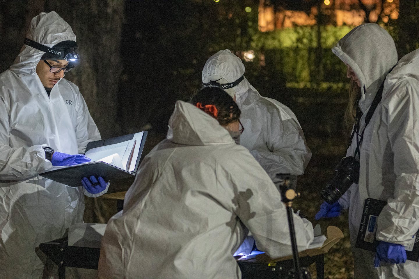 Students in protective suits including Brandon Taylor, far left, evaluate a mock crime scene in St. Paul, Minn., on Tuesday, Nov. 21, 2023. Every year Hamline University Professor Jamie Spaulding calls his students out in the middle of the night to investigate a staged crime scene as part of his forensic science class] RICHARD TSONG-TAATARII • richard.tsong-taatarii @startribune.com