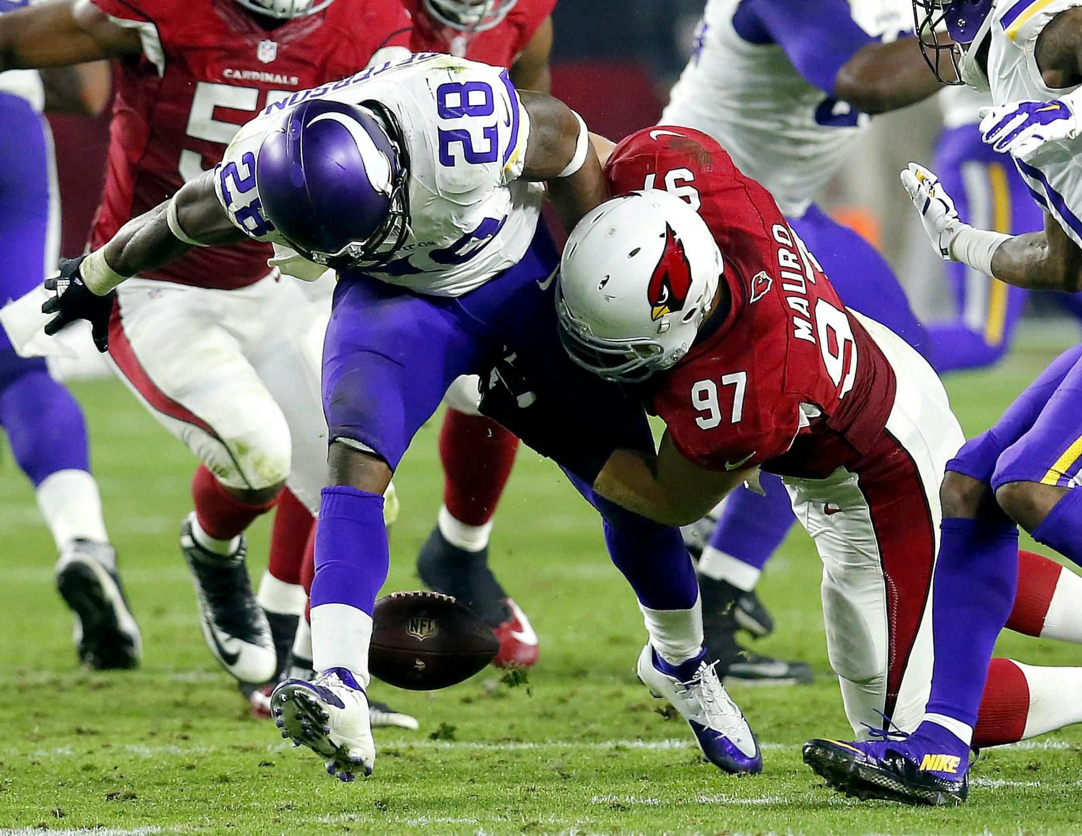 Minnesota Vikings running back Adrian Peterson (28) fumbles after being hit by Arizona Cardinals nose tackle Josh Mauro (97) during the second half of an NFL football game, Thursday, Dec. 10, 2015, in Glendale, Ariz. (AP Photo/Rick Scuteri) ORG XMIT: MIN2016011520545302