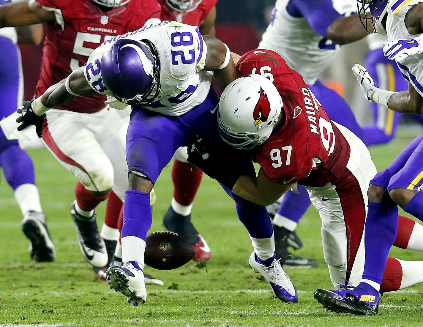 Minnesota Vikings running back Adrian Peterson (28) fumbles after being hit by Arizona Cardinals nose tackle Josh Mauro (97) during the second half of an NFL football game, Thursday, Dec. 10, 2015, in Glendale, Ariz. (AP Photo/Rick Scuteri) ORG XMIT: MIN2016011520545302