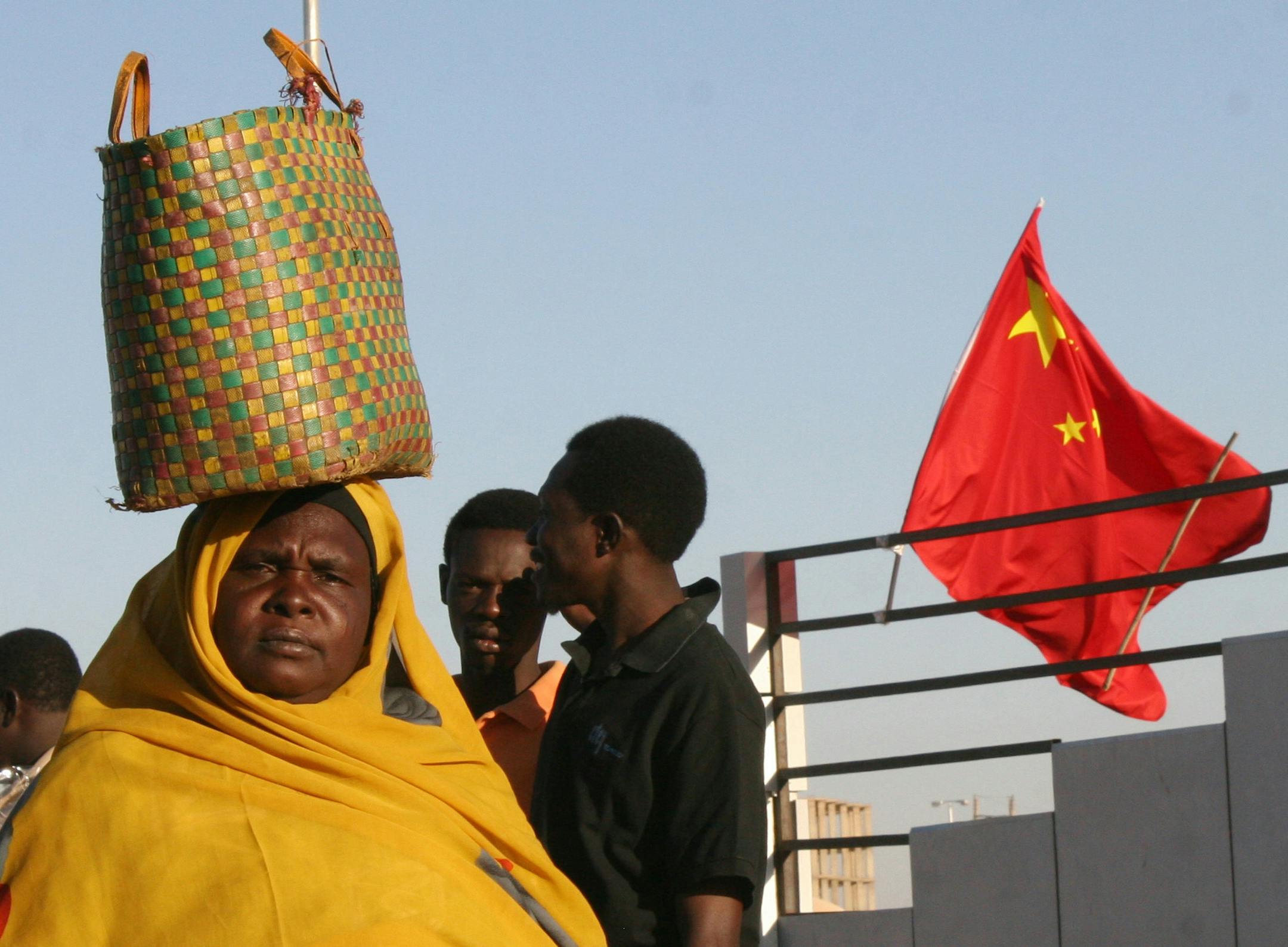 ** ADVANCE TO GO WITH STORY EU REDISCOVERS AFRICA **A Sudanese woman walks past a Chinese flag on a street in Khartoum, in this Thursday Feb. 1, 2007 file photo. Ahead of an EU Africa summit scheduled to begin in Lisbon on Dec. 8, 2007 the EU is concerned that the search by China and other rising powers for oil and other resources across Africa comes with no demands for democracy and human rights. (AP Photo/Alfred de Montesquiou, File) ORG XMIT: VLM803
