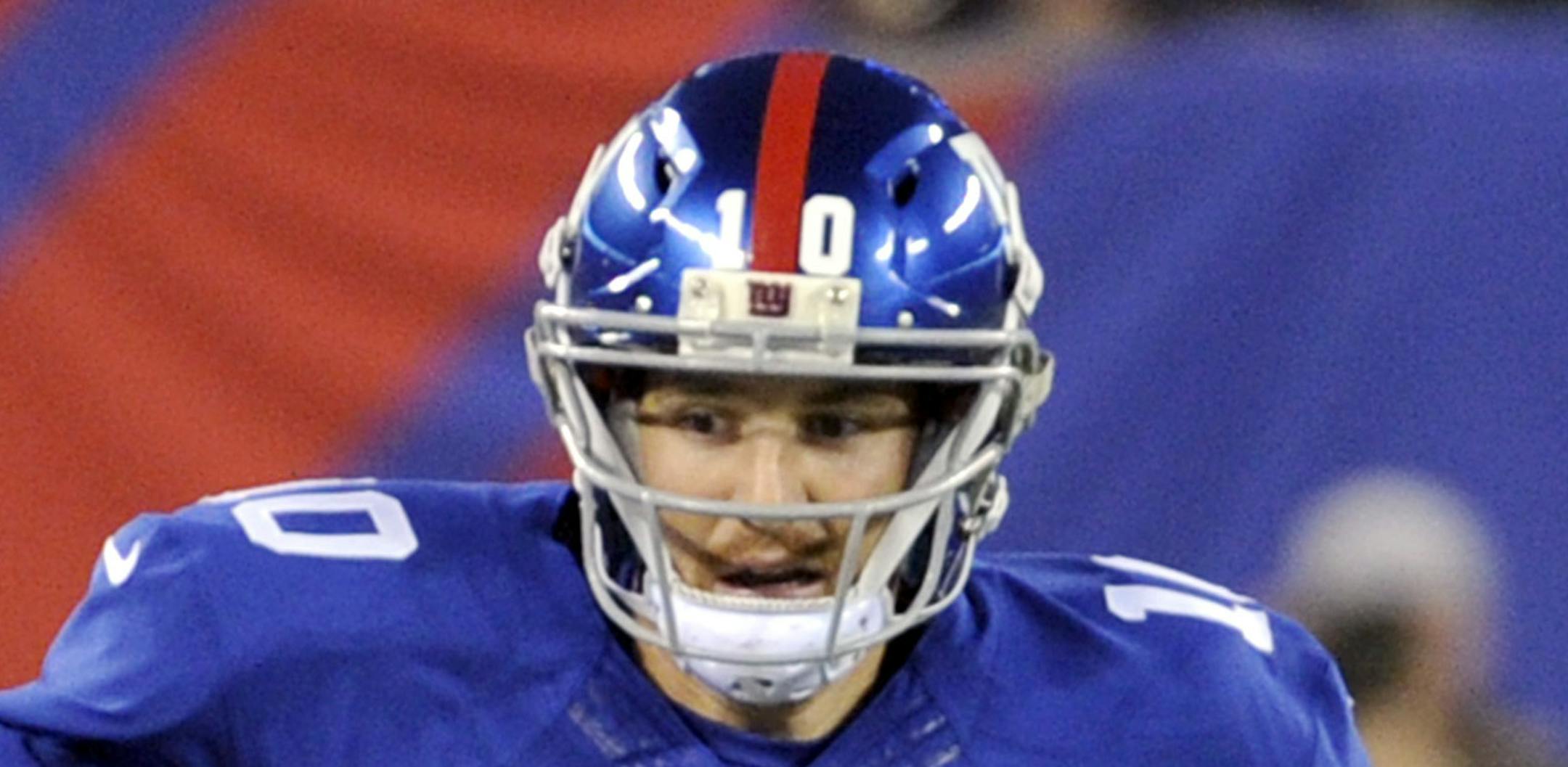 New York Giants quarterback Eli Manning picks up yardage during the first half of an NFL football game against the Green Bay Packers Sunday, Nov. 17, 2013, in East Rutherford, N.J. (AP Photo/Bill Kostroun)