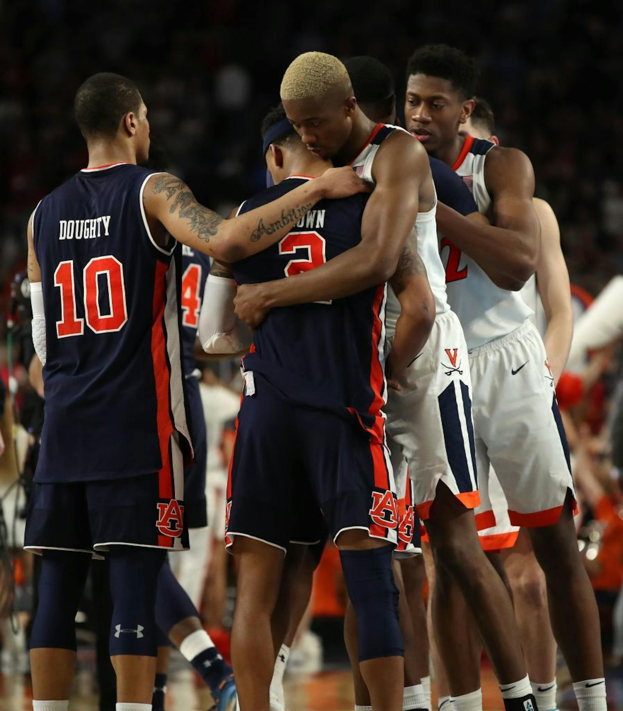 Auburn guard Bryce Brown (2) is embraced by Virginia Cavaliers forward Mamadi Diakite (25) near Auburn guard Samir Doughty (10) after Virginia won the game.