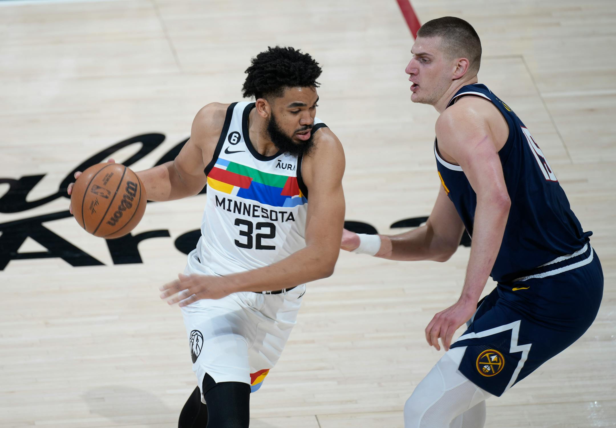 Minnesota Timberwolves center Karl-Anthony Towns, left, drives against Denver Nuggets center Nikola Jokic during the first half of Game 2 in an NBA basketball first-round playoff series Wednesday night in Denver.