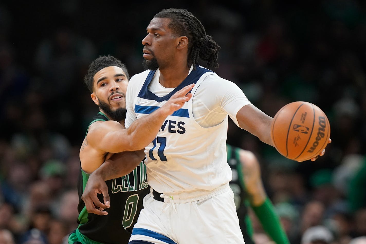 Boston Celtics forward Jayson Tatum (0) vies with Minnesota Timberwolves center Naz Reid (11), right, in the first half of an NBA basketball game, Sunday, March 27, 2022, in Boston. (AP Photo/Steven Senne)