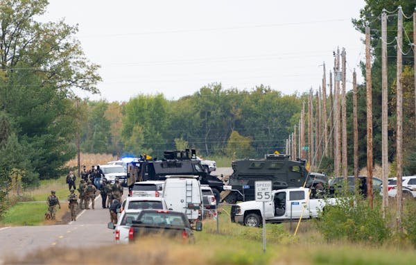 Law enforcement gathered outside of a residence where a man suspected of shooting multiple officers was in a standoff Thursday near Princeton, Minn.
