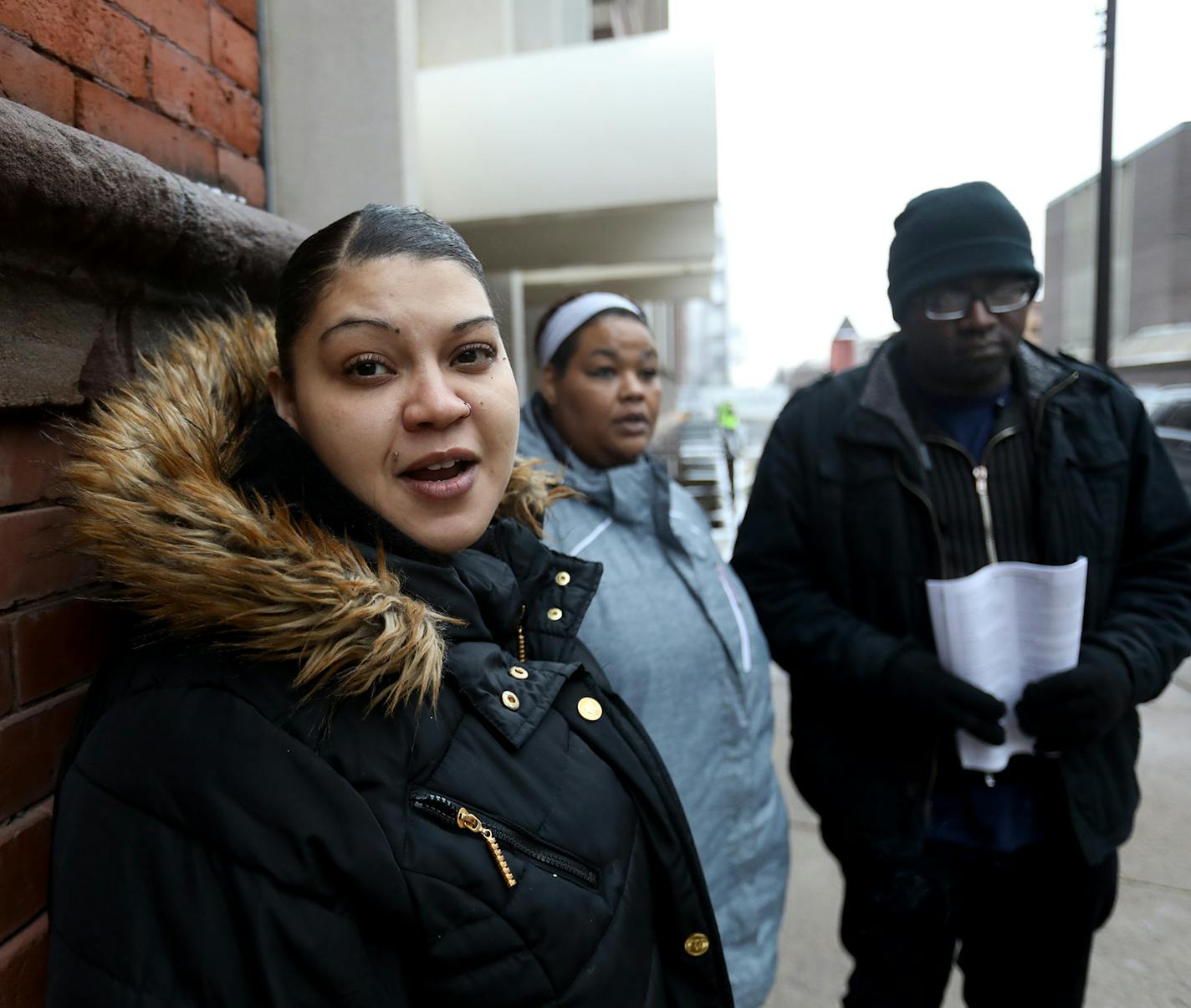 Minneapolis residents displaced by the Christmas Day at the Francis Drake Hotel apartment stand outside a temporary shelter set up at the First Covenant Church Minneapolis Thursday, Jan. 2, 2020, in Minneapolis, MN. Discussing their fate is Domonique Howell, left to right, Tavonne Moses, and Damian Ashcraft . All three work and paid to live at the Drake but feel as though information is being withheld from them as well as donated funding that could get them back in a home. &#x201c;We just want o