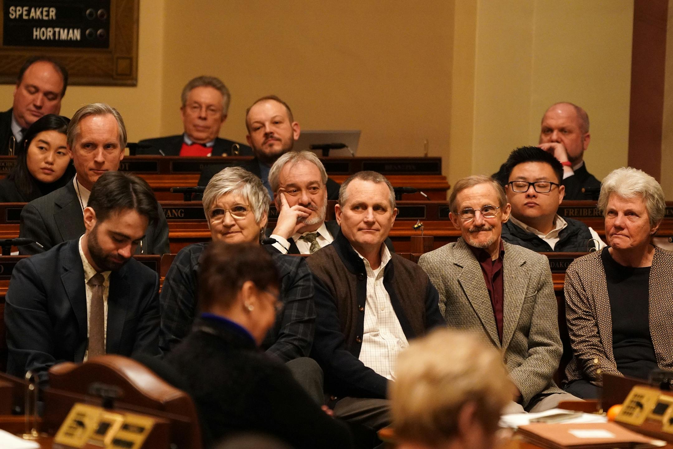 Family of the late Rep. Diane Loeffler, D-Minneapolis, including her husband Mike Vennewitz, second from right, listened as fellow representatives paid tribute to her after session had adjourned Tuesday.