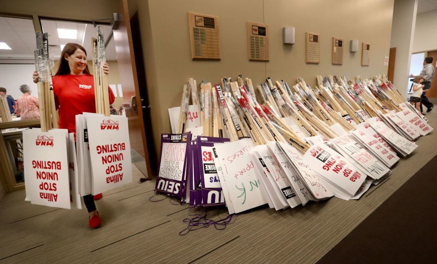 Valerie Johnson, an RN at Abbott Northwestern Hospital, added to the pile as MNA nurses, Minnesota Nurses Association employees and family members joined forces at the MNA headquarters to make posters for picketing Saturday, June 18, 2016.