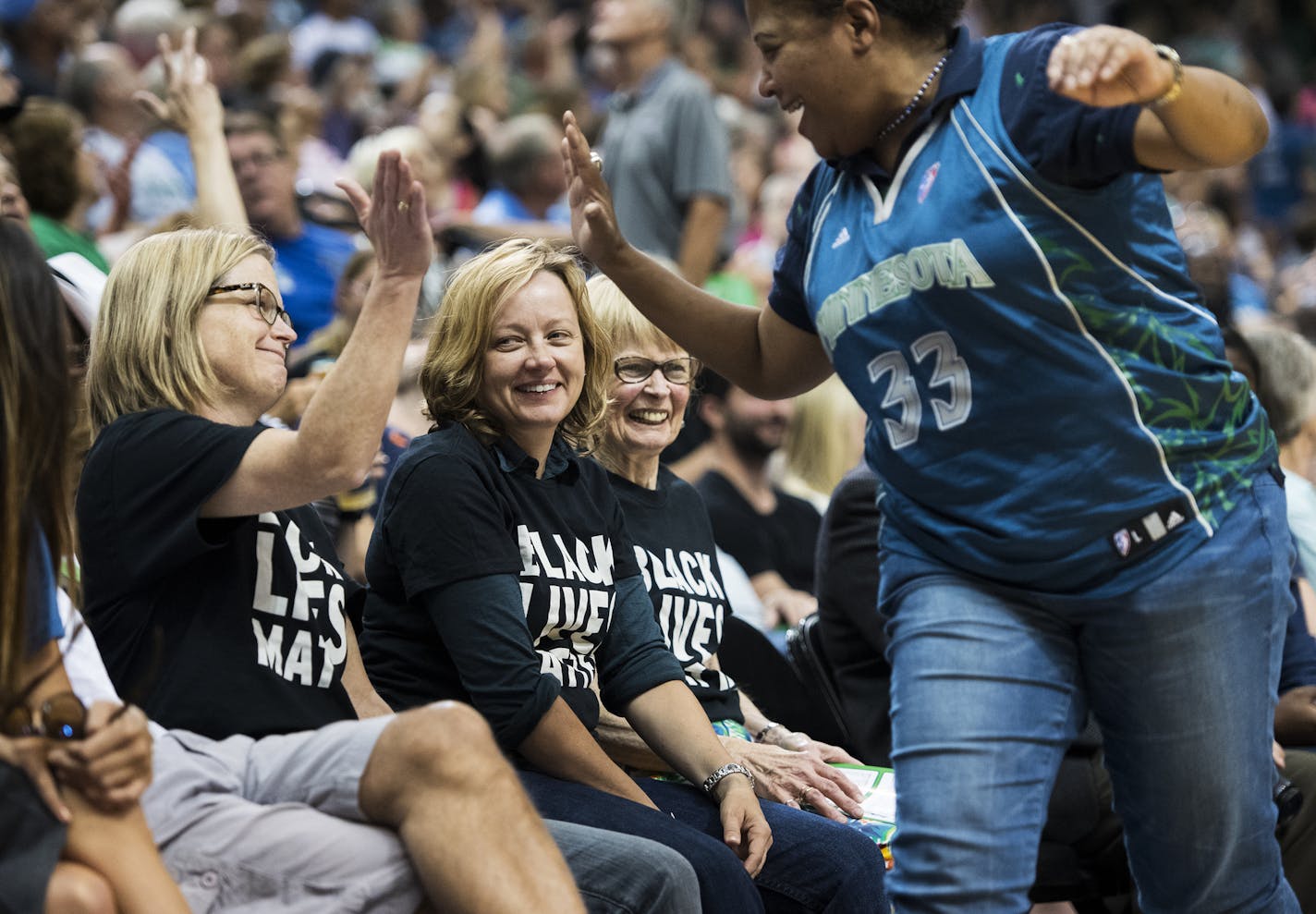 Cindy Booker, right, high-fived Vija Brookshire after high-fiving their mutual friends Julieann Swanson, center, and Jacqueline Teisberg. The three wore Black Lives Matter shirts to Friday night's Lynx game. ] Isaac Hale &#x2022; isaac.hale@startribune.com The Minnesota Lynx took on the New York Liberty at the Target Center on Friday, July 15, 2016.